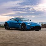 blue porsche 911 on brown sand under white clouds during daytime