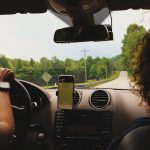 a woman driving a car while holding a cell phone
