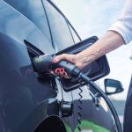 a person pumping gas into a car at a gas station