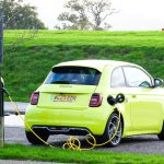 a yellow car is plugged into a charging station